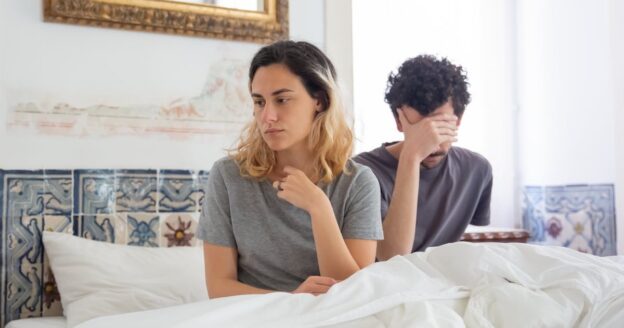 Couple sitting in bed having a disagreement